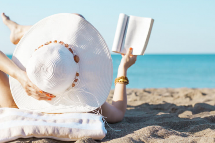 woman reading a book on the beach